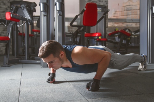 Sport. Young athletic man doing push-ups